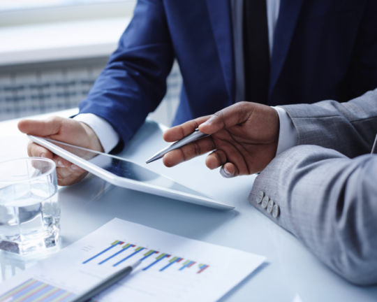 two people working on financial information on ipad